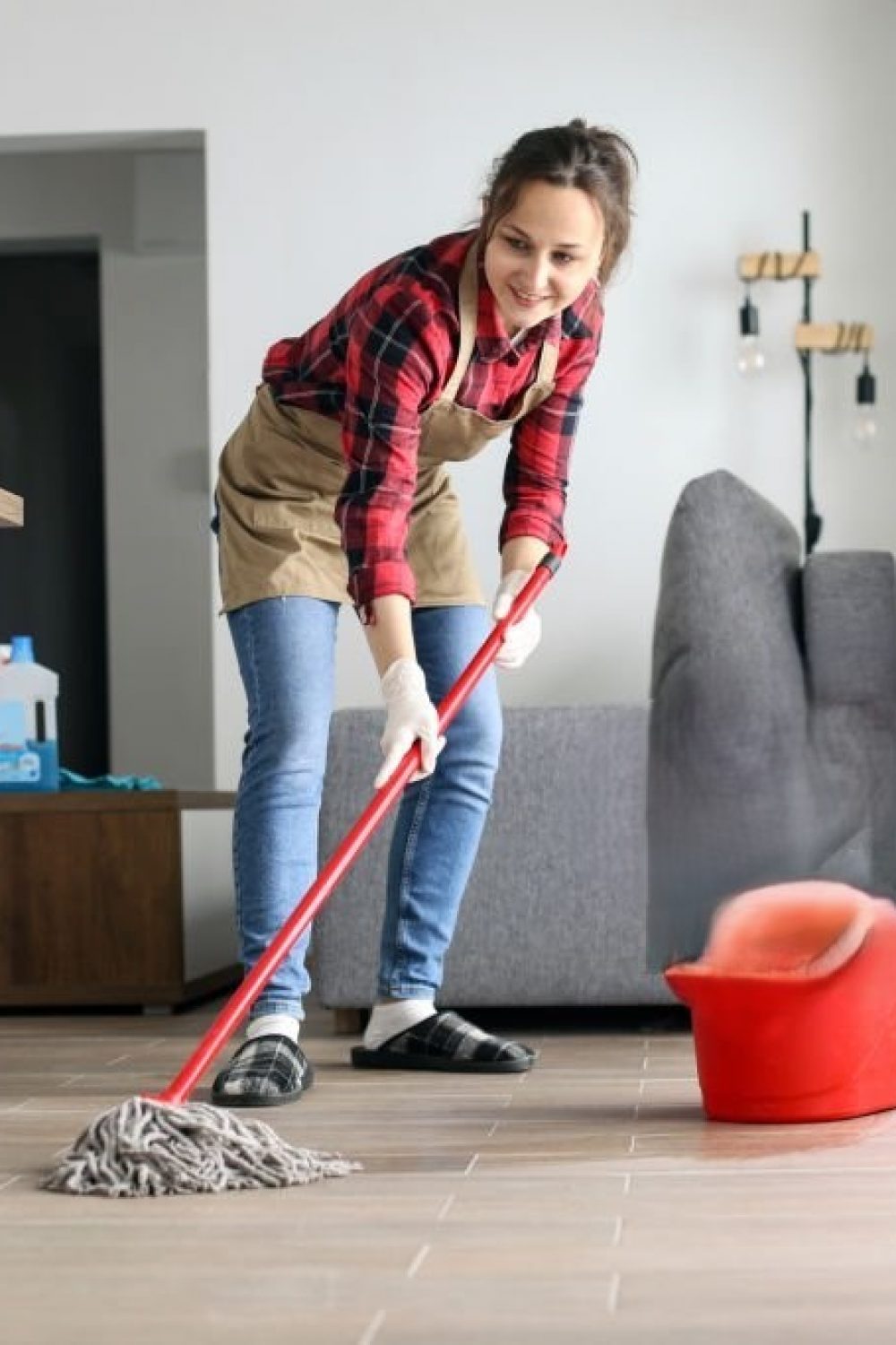 Young woman doing chores, cleaning floor of the house. About 20 years old, Caucasian female.