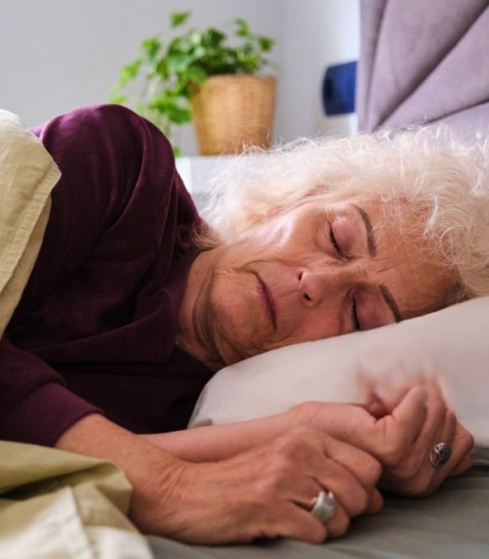 Mature Hispanic woman sleeping on her bed. Oversleep, asleep.